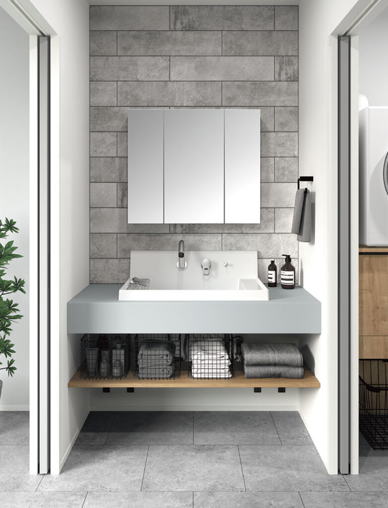 グレーのカウンターに白のスクエアボウルと三面鏡を合わせたカスタムバニティ。下部はオープン棚の収納。